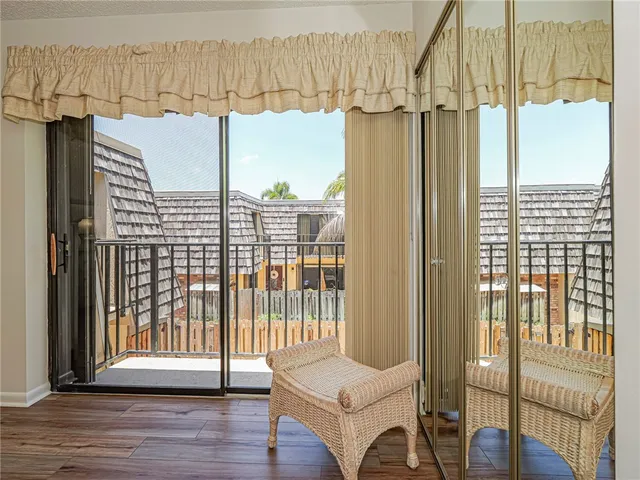 a view of a bedroom with wooden floor and windows