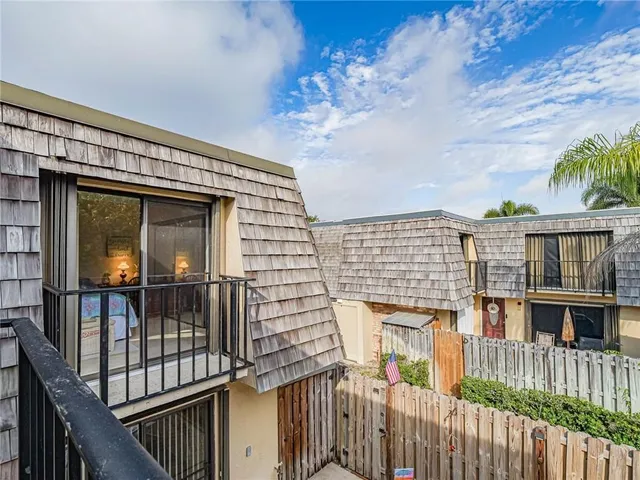 a view of a house with wooden deck front of house