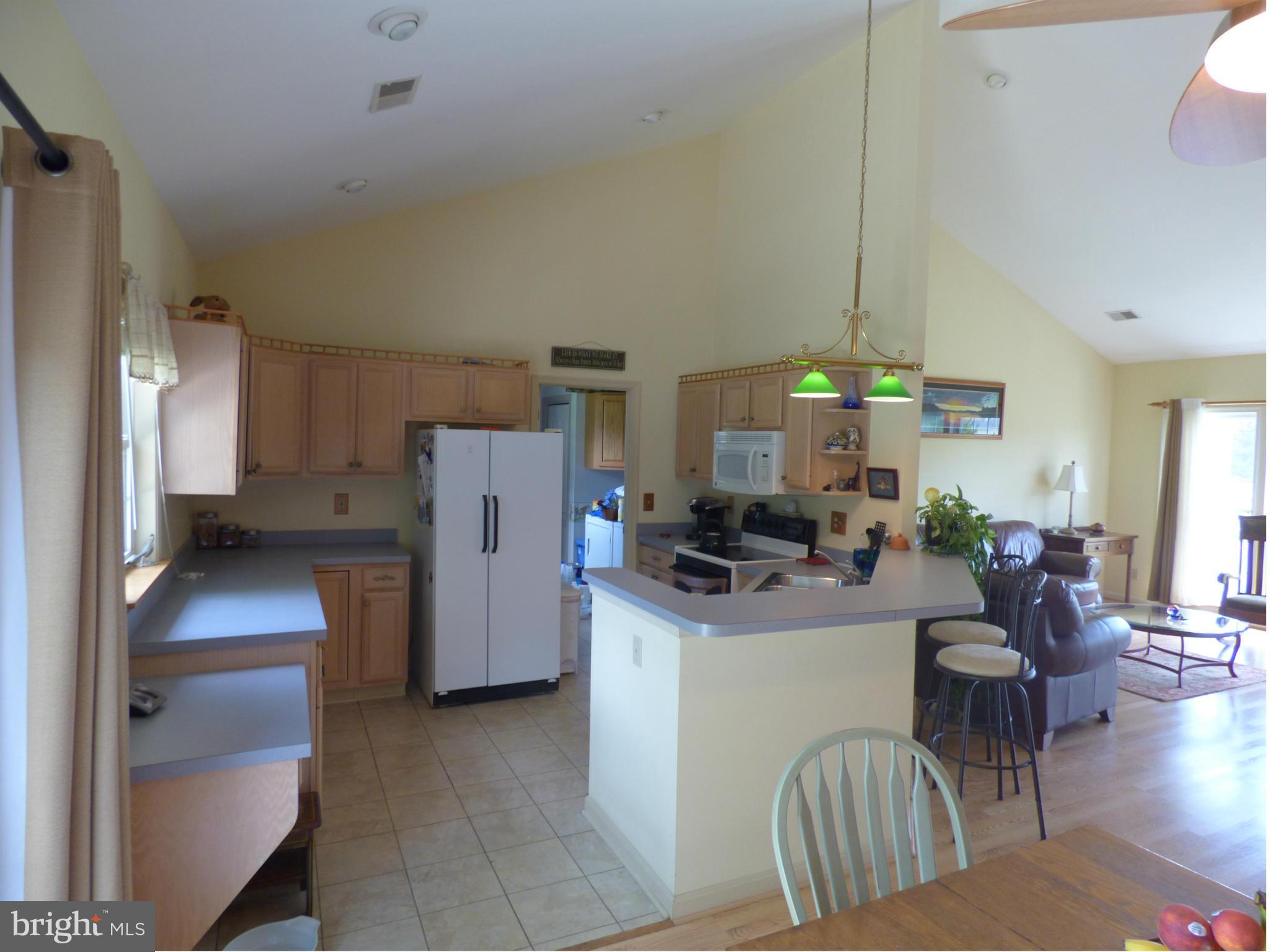 105 Myers Road Chestertown, MD 21620 - Photo 13 of 30 a kitchen with stainless steel appliances granite countertop a refrigerator a stove a sink a dining table and chairs with wooden floor