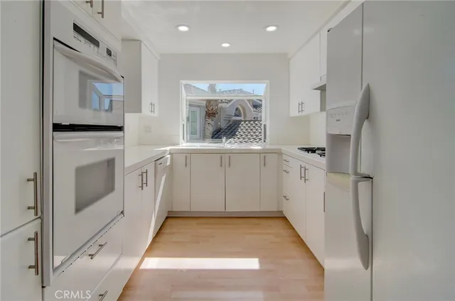a kitchen with white cabinets and white appliances