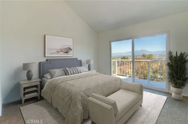 a bedroom with a bed couch and a large window