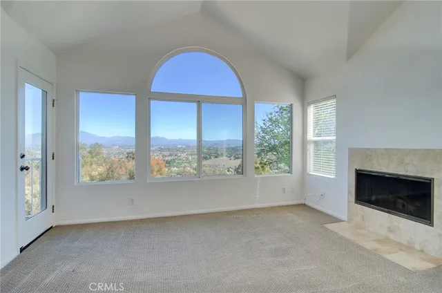 a view of an empty room with a fireplace and a window