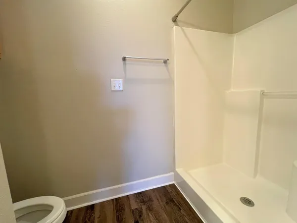 a bathroom with a granite countertop shower and a toilet
