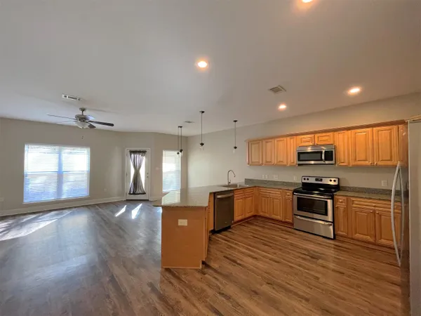 an open kitchen with kitchen island and stainless steel appliances