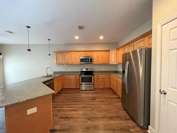 a kitchen with granite countertop a refrigerator and a sink
