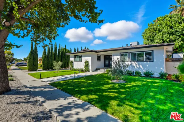 a view of a house with backyard and a tree