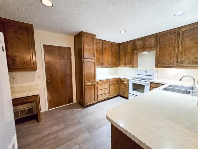 a kitchen with a refrigerator sink and cabinets