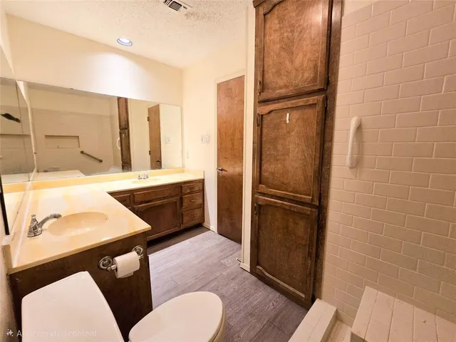 a bathroom with a sink a toilet a mirror and shower