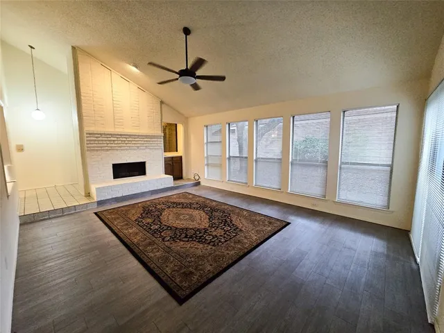 a living room with wooden floor and a fireplace