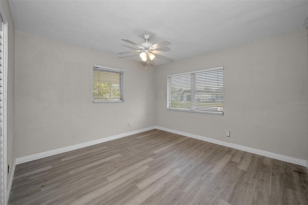 2476 Coronado Way Dunedin, FL 34698 - Photo 17 of 81 an empty room with wooden floor chandelier fan and windows