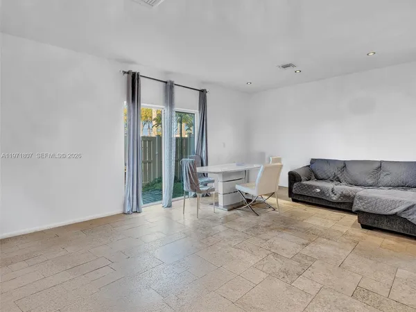a living room with furniture and a dining table