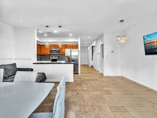 a view of kitchen with kitchen island stainless steel appliances refrigerator stove microwave and cabinets