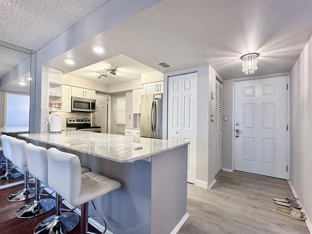 5301 Northwest 2nd Avenue, Unit 408 Boca Raton, FL 33487 - Photo 1 of 32 a large kitchen with kitchen island a large counter space and stainless steel appliances