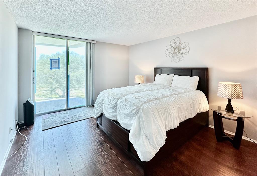 5301 Northwest 2nd Avenue, Unit 408 Boca Raton, FL 33487 - Photo 13 of 32 a bedroom with a bed and wooden floor