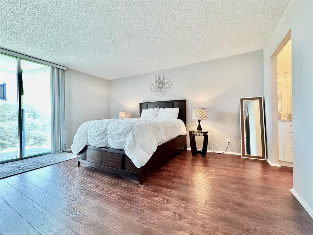 5301 Northwest 2nd Avenue, Unit 408 Boca Raton, FL 33487 - Photo 14 of 32 a living room with a bed furniture and a large window
