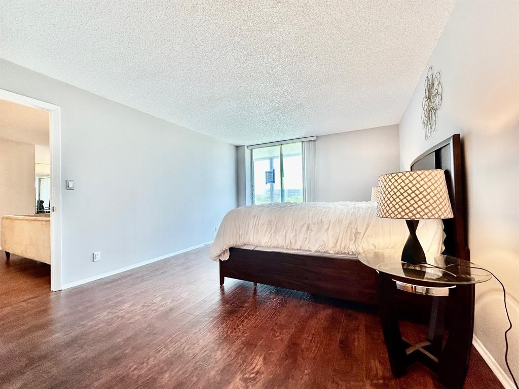 5301 Northwest 2nd Avenue, Unit 408 Boca Raton, FL 33487 - Photo 15 of 32 a bedroom with a bed and wooden floor