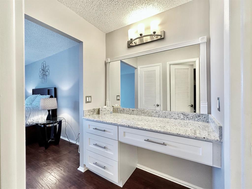 5301 Northwest 2nd Avenue, Unit 408 Boca Raton, FL 33487 - Photo 16 of 32 a en suite bathroom with a granite countertop sink and a mirror