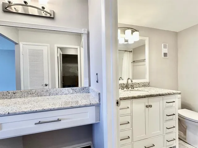 a bathroom with a granite countertop sink and a mirror