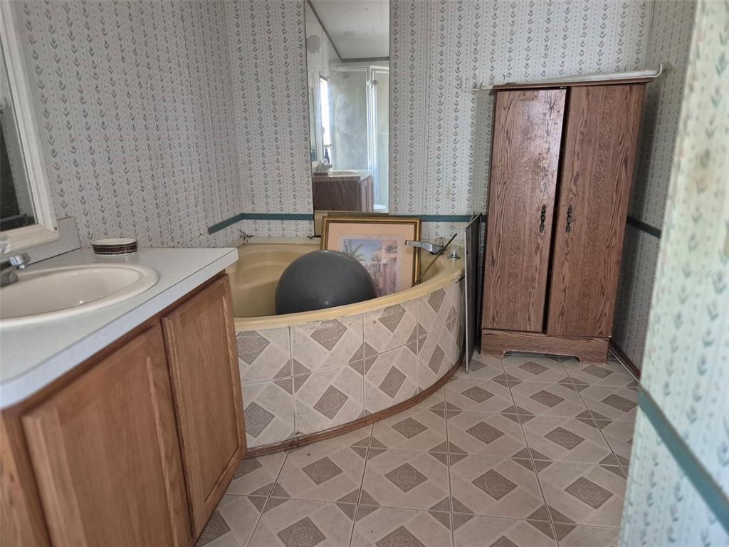 11651 Northeast 73rd Lane Bronson, FL 32621 - Photo 38 of 39 a bathroom with a double vanity sink a mirror and shower