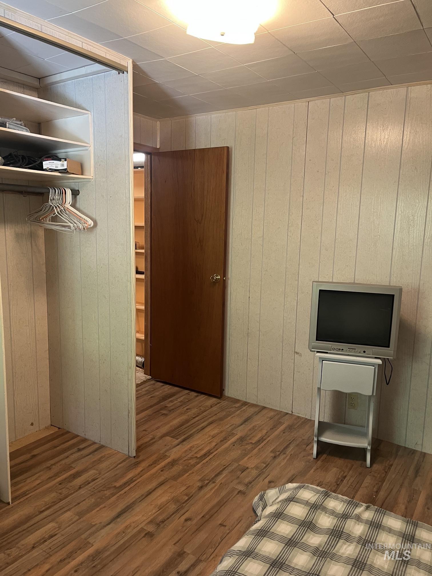 39 Mayflower Mine Road Placerville, ID 83666 - Photo 34 of 36 Room featuring wood-finish flooring, vertical paneling, and a flush-mount ceiling light