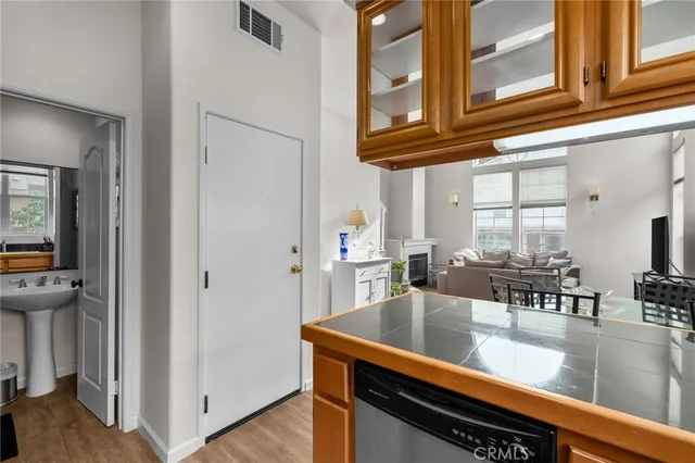 a kitchen with stainless steel appliances granite countertop a coffee maker on granite counter tops and a view of living room