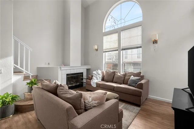 a living room with furniture a fireplace and a large window