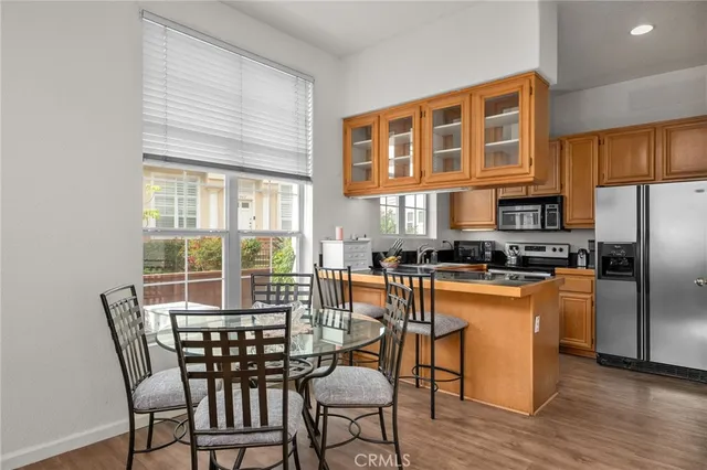 a dining room with furniture a kitchen view and wooden floor