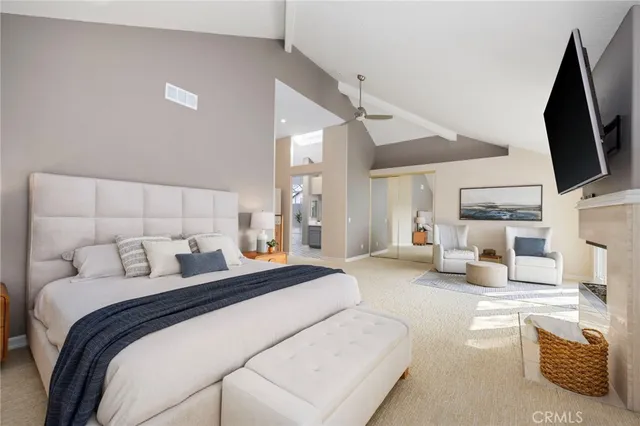 a bedroom with a bed couch tv and a large window