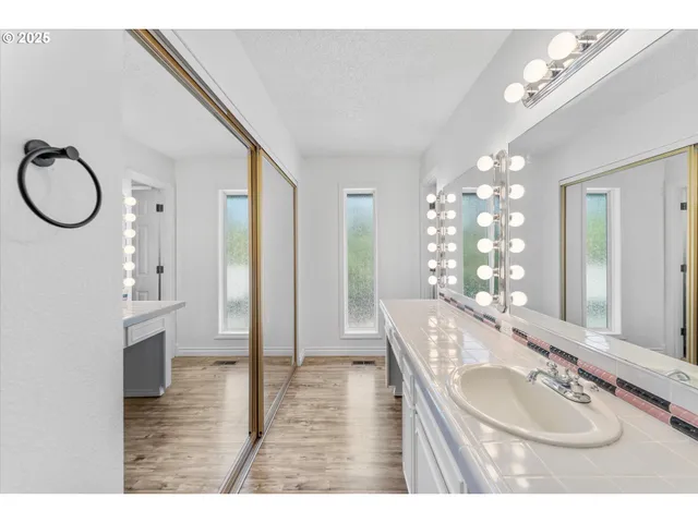 a bathroom with a granite countertop sink a mirror and a shower