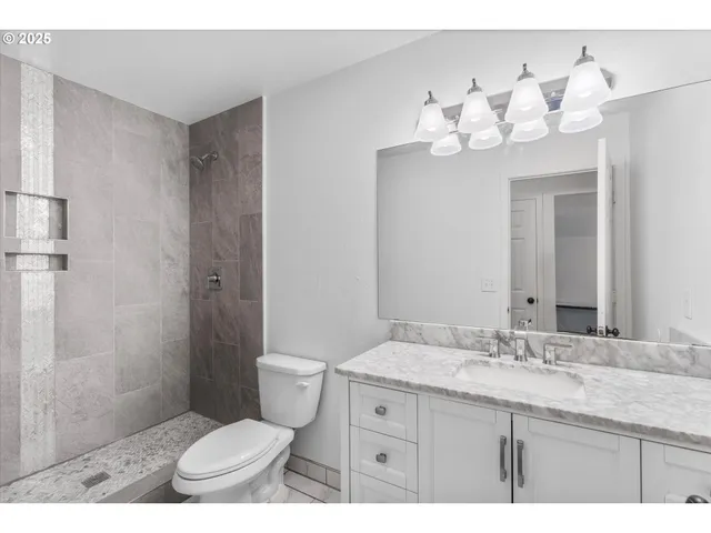 a bathroom with a sink vanity mirror and toilet