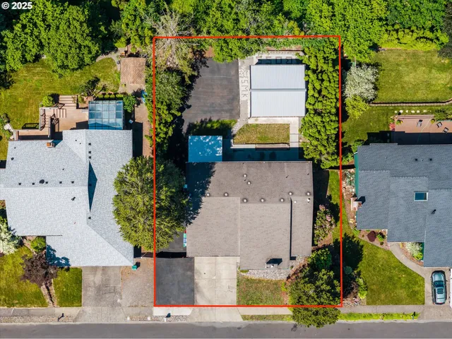 an aerial view of a house with a yard and a large tree