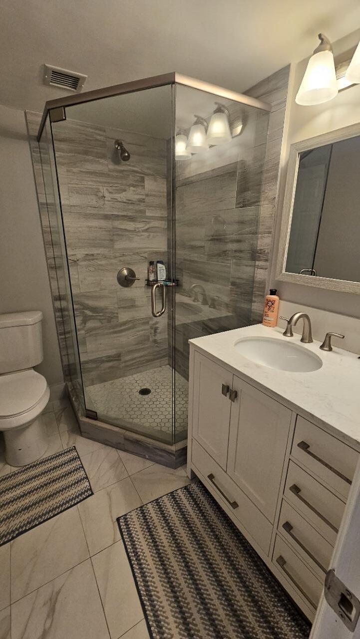 4 Royal Palm Way, Unit 6050 Boca Raton, FL 33432 - Photo 29 of 35 a bathroom with a double vanity sink toilet and shower