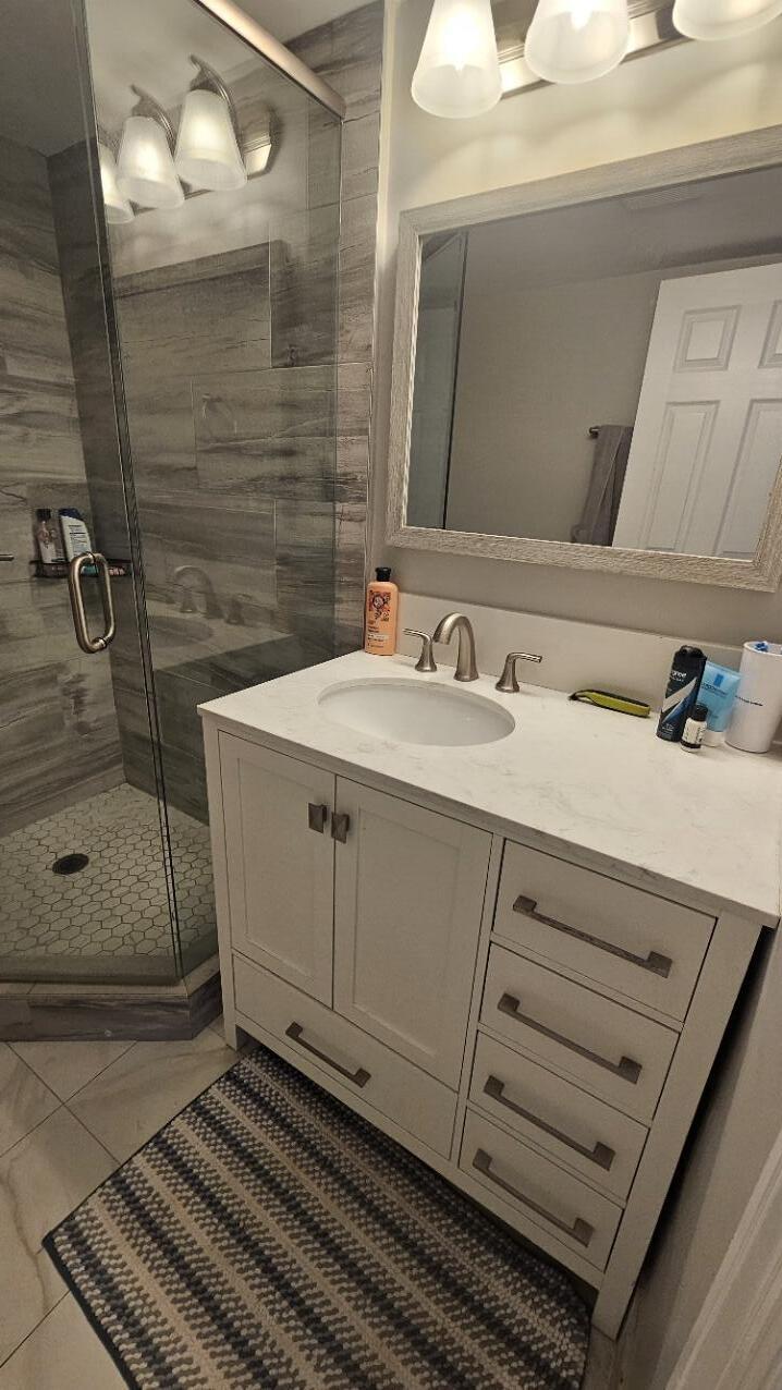 4 Royal Palm Way, Unit 6050 Boca Raton, FL 33432 - Photo 30 of 35 a bathroom with a sink a mirror and shower