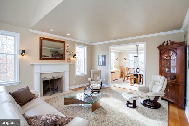 a living room with furniture a dining table and a chandelier