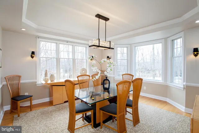 a kitchen with stainless steel appliances kitchen island granite countertop a table chairs microwave and refrigerator