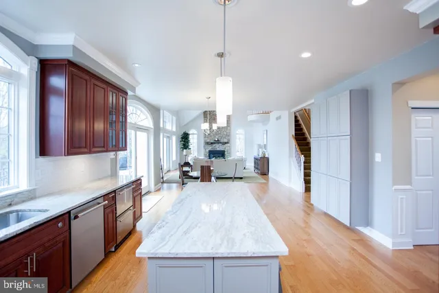 a spacious bathroom with stainless steel appliances granite countertop a sink dishwasher stove and wooden floor