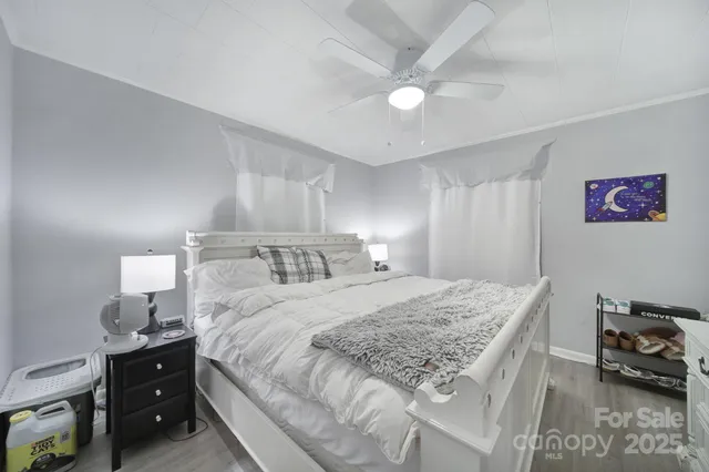 a bedroom with a bed and a lamp on dresser