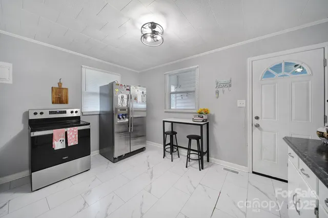 a kitchen with a refrigerator and a stove top oven