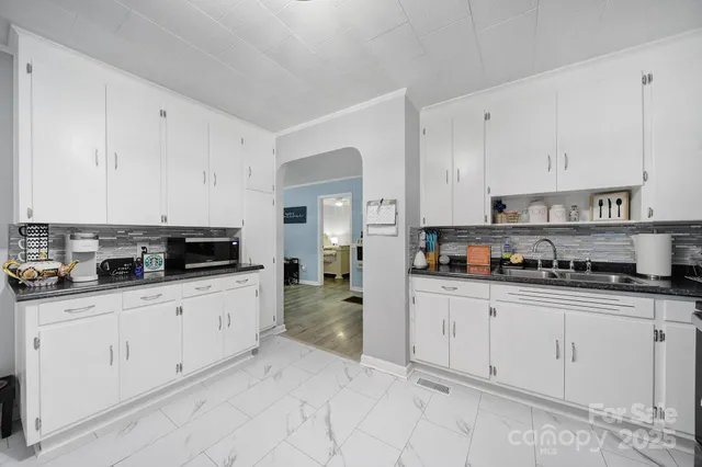 a kitchen with granite countertop white cabinets and appliances