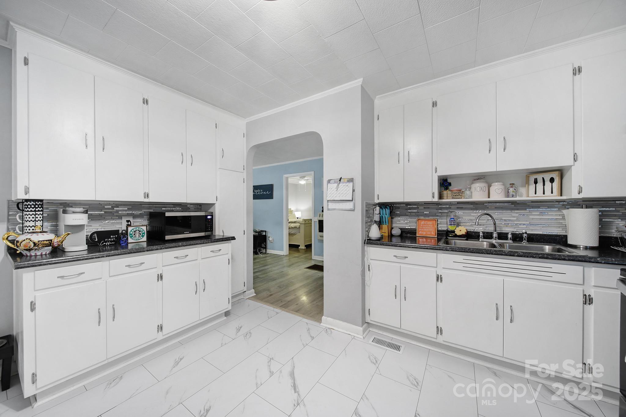 1306 Church Street Lancaster, SC 29720 - Photo 9 of 26 a kitchen with granite countertop white cabinets and appliances