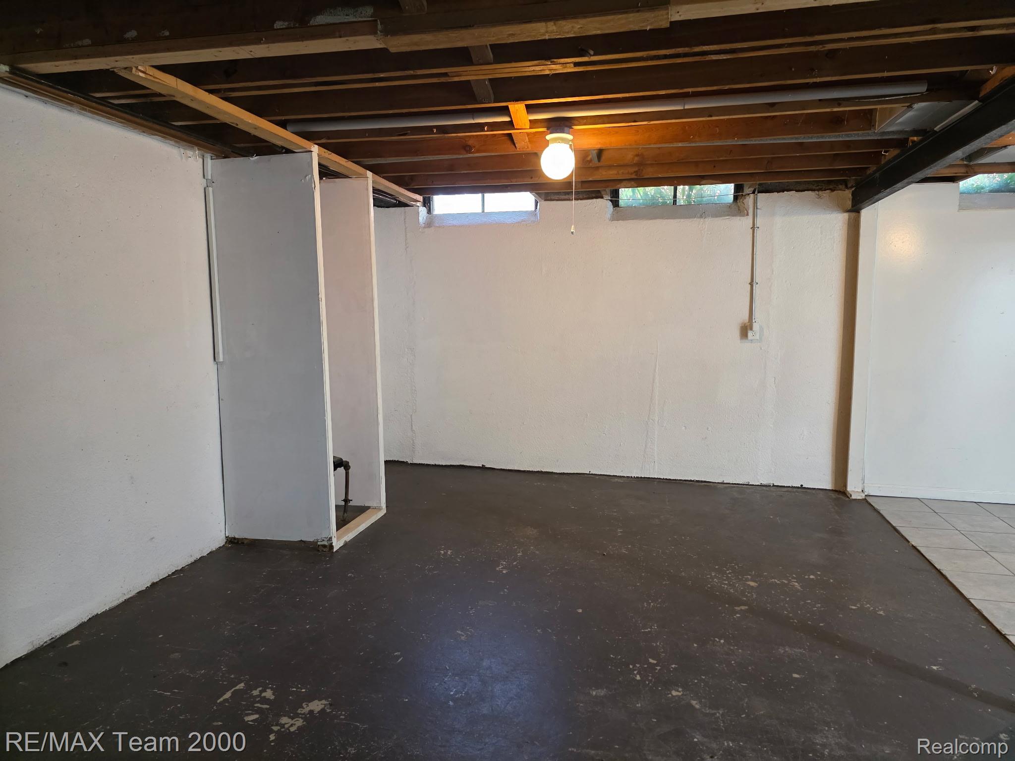 38114 Walnut Street Romulus, MI 48174 - Photo 11 of 18 Spacious unfinished basement featuring exposed ceiling joists, concrete flooring, white painted walls, and multiple small windows