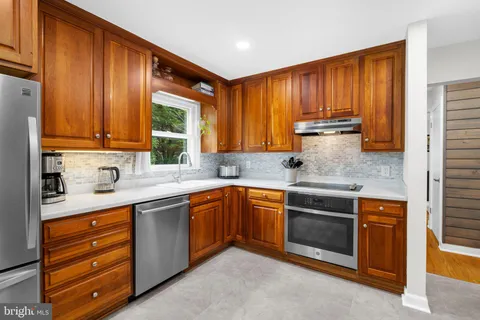 a kitchen with stainless steel appliances granite countertop a refrigerator and a sink