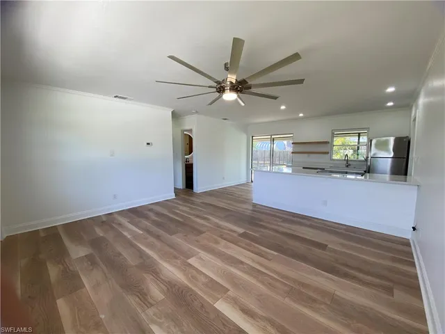 a view of an empty room and kitchen view