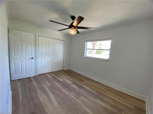 an empty room with windows and fan