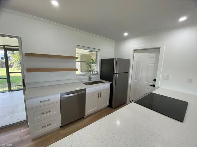 a kitchen with a refrigerator and a stove top oven