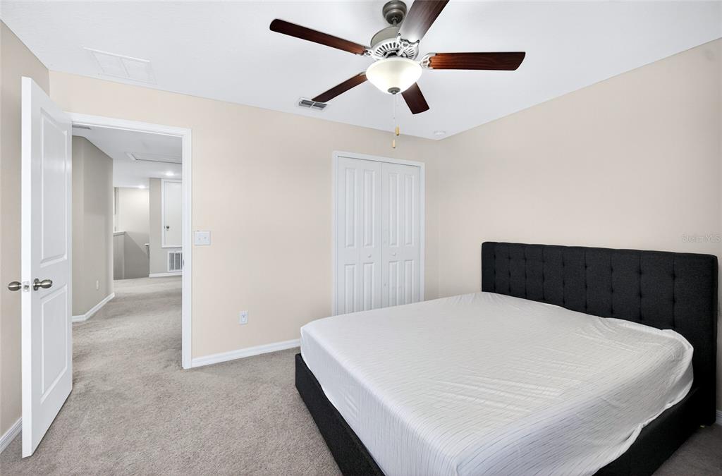31724 Sun Kettle Loop Wesley Chapel, FL 33545 - Photo 27 of 49 a bedroom with a large bed and a chandelier