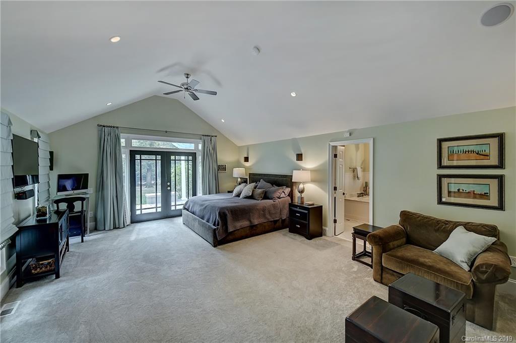 859 Museum Drive Charlotte, NC 28207 - Photo 12 of 23 a spacious bedroom with a bed a couch and a chandelier