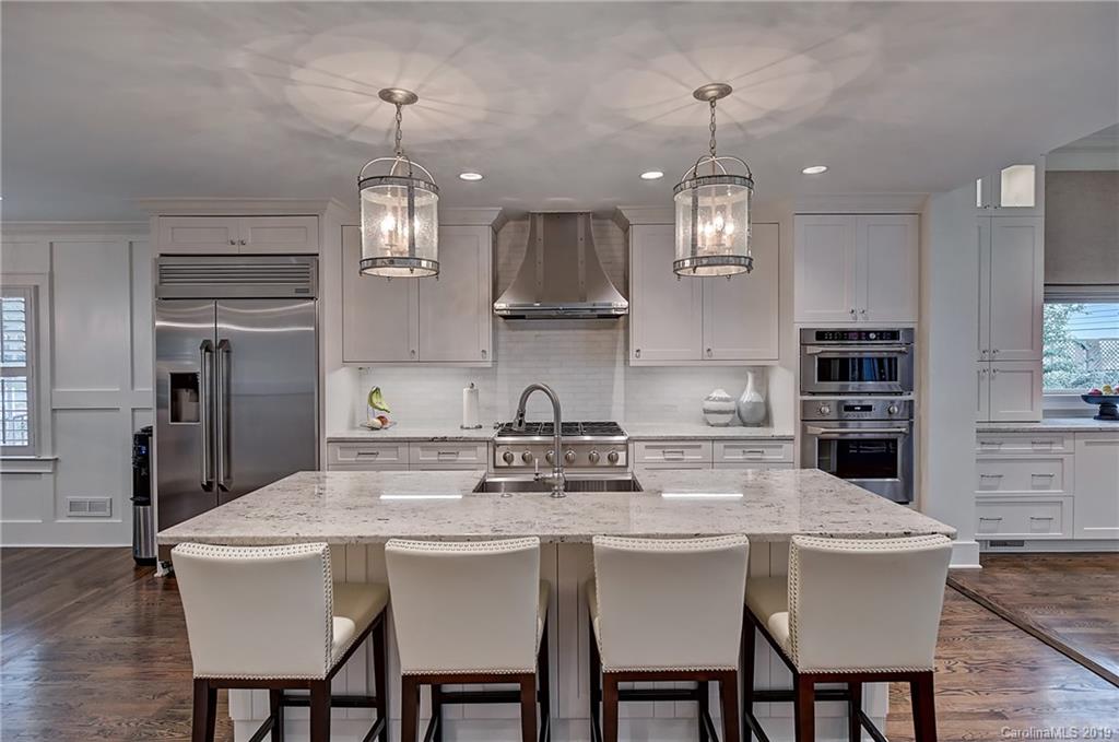 859 Museum Drive Charlotte, NC 28207 - Photo 8 of 23 a kitchen with stainless steel appliances granite countertop a dining table chairs refrigerator and stove