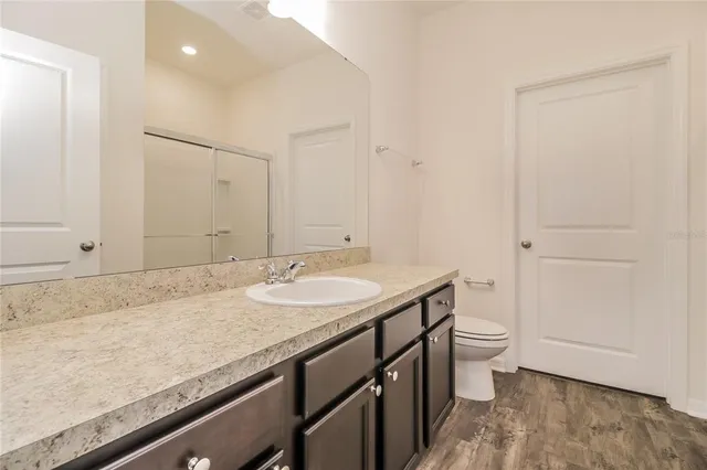 a bathroom with a granite countertop sink and a mirror
