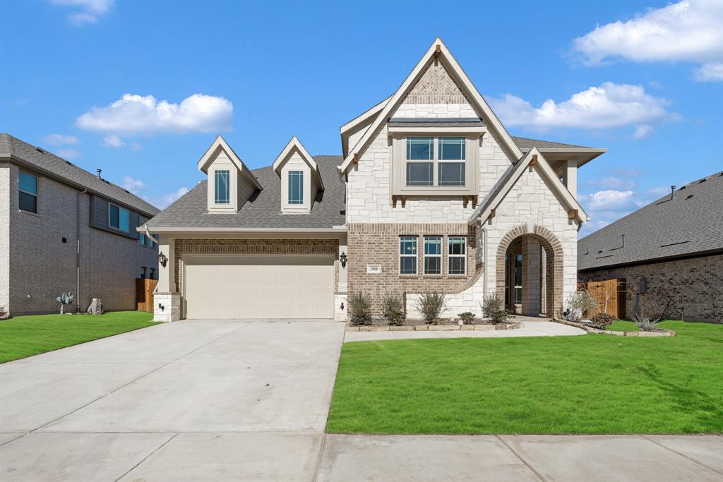 a front view of a house with a yard and garage